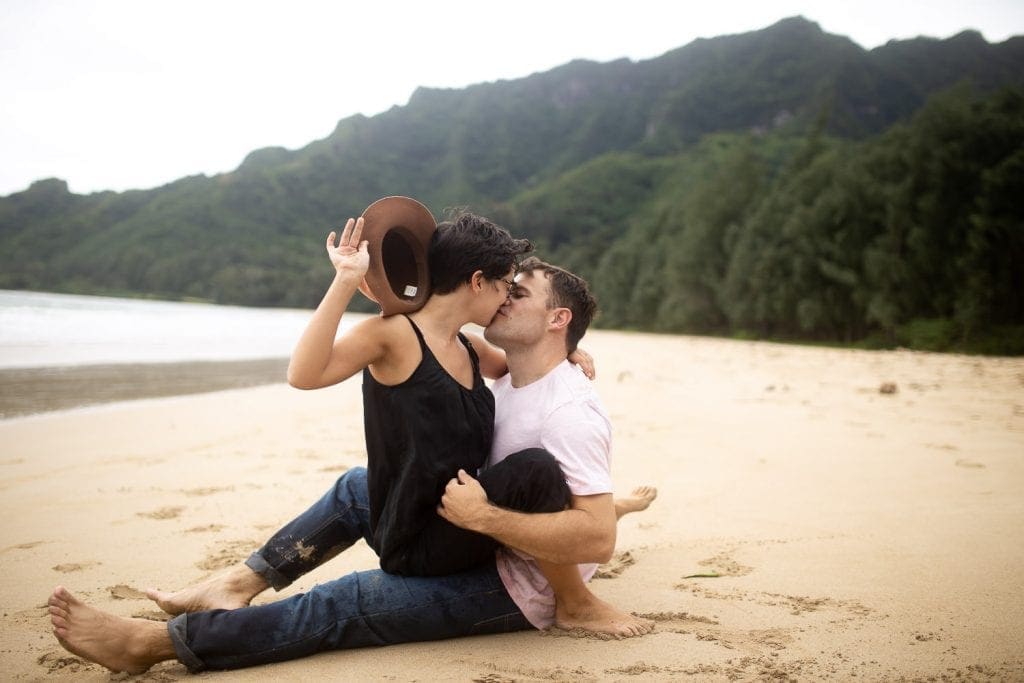 a couple sitting on the beach kissing and holding each other. destination wedding photographer.