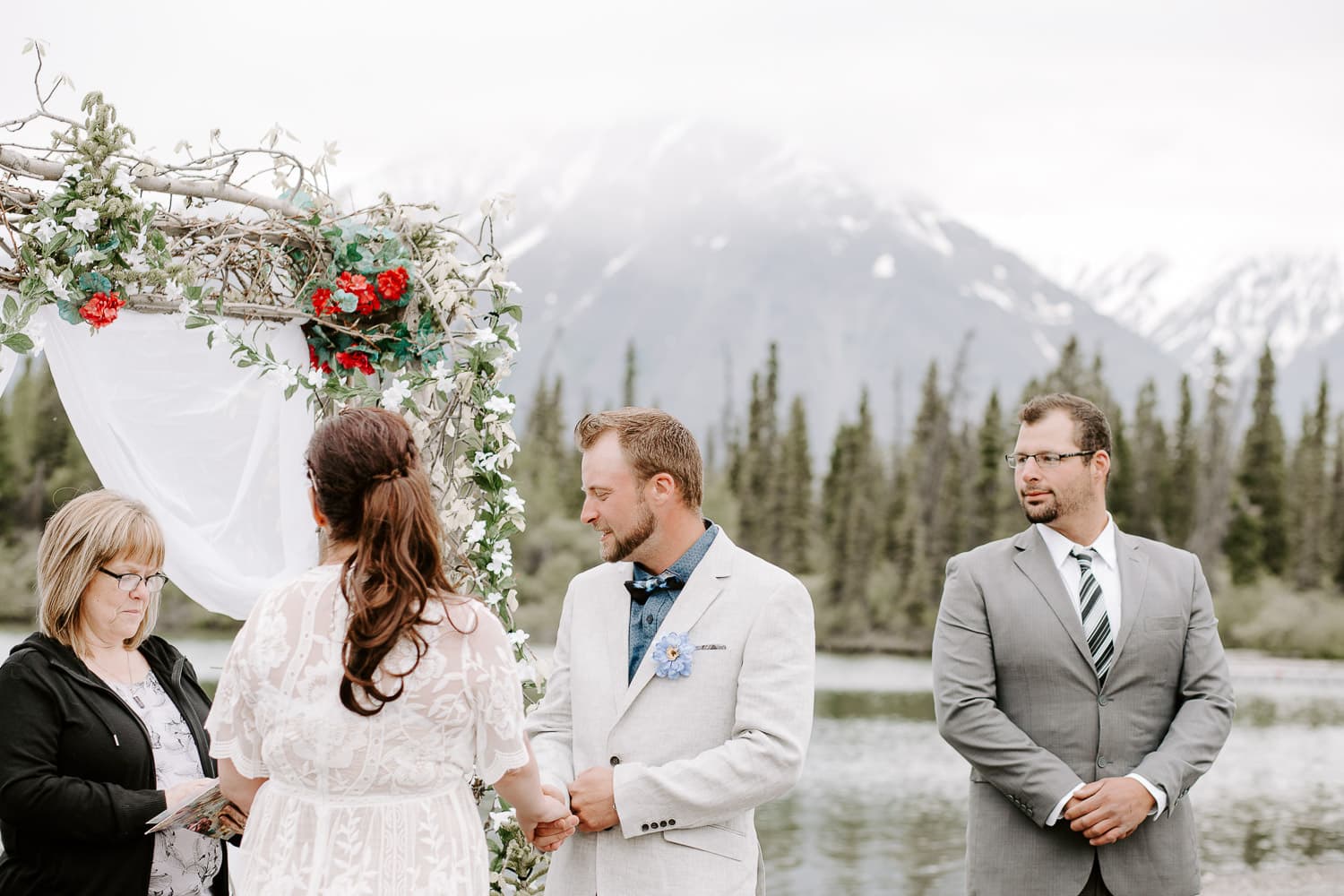 a bride and groom getting married in front of a glacier lake and mountains. destination wedding photographer.