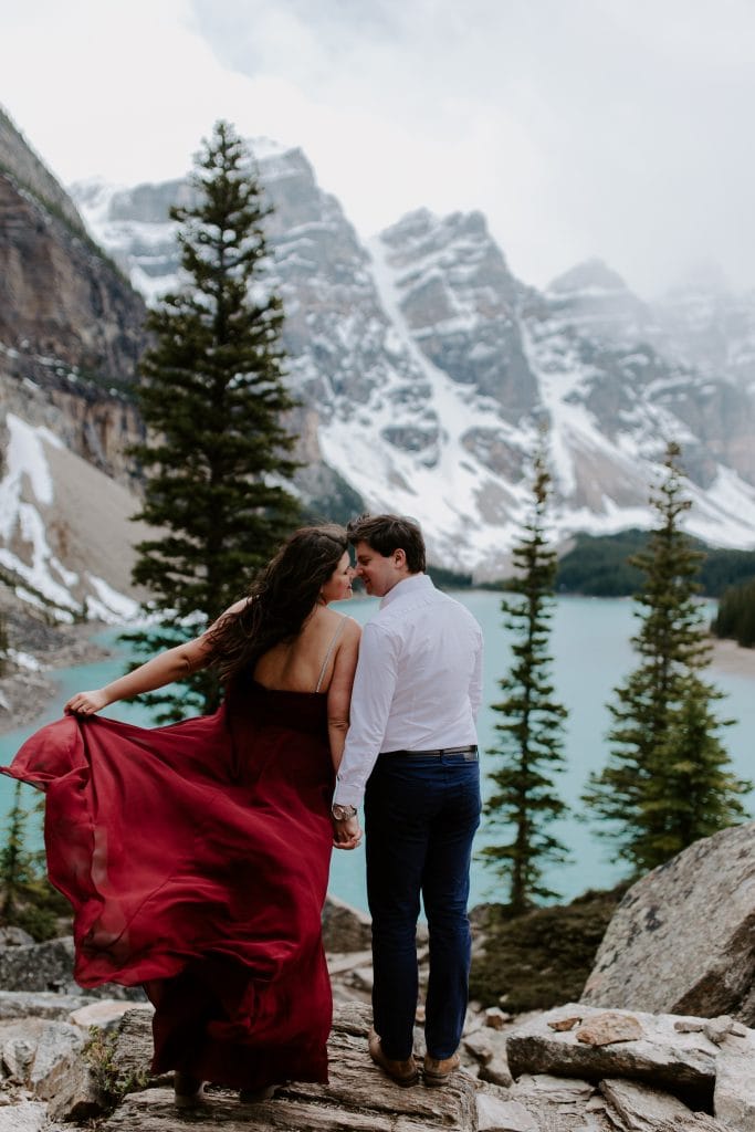 Couple kissing in front of a glacier lake and mountains at their Small Wedding Elopement. Banff Elopement Photographer.
