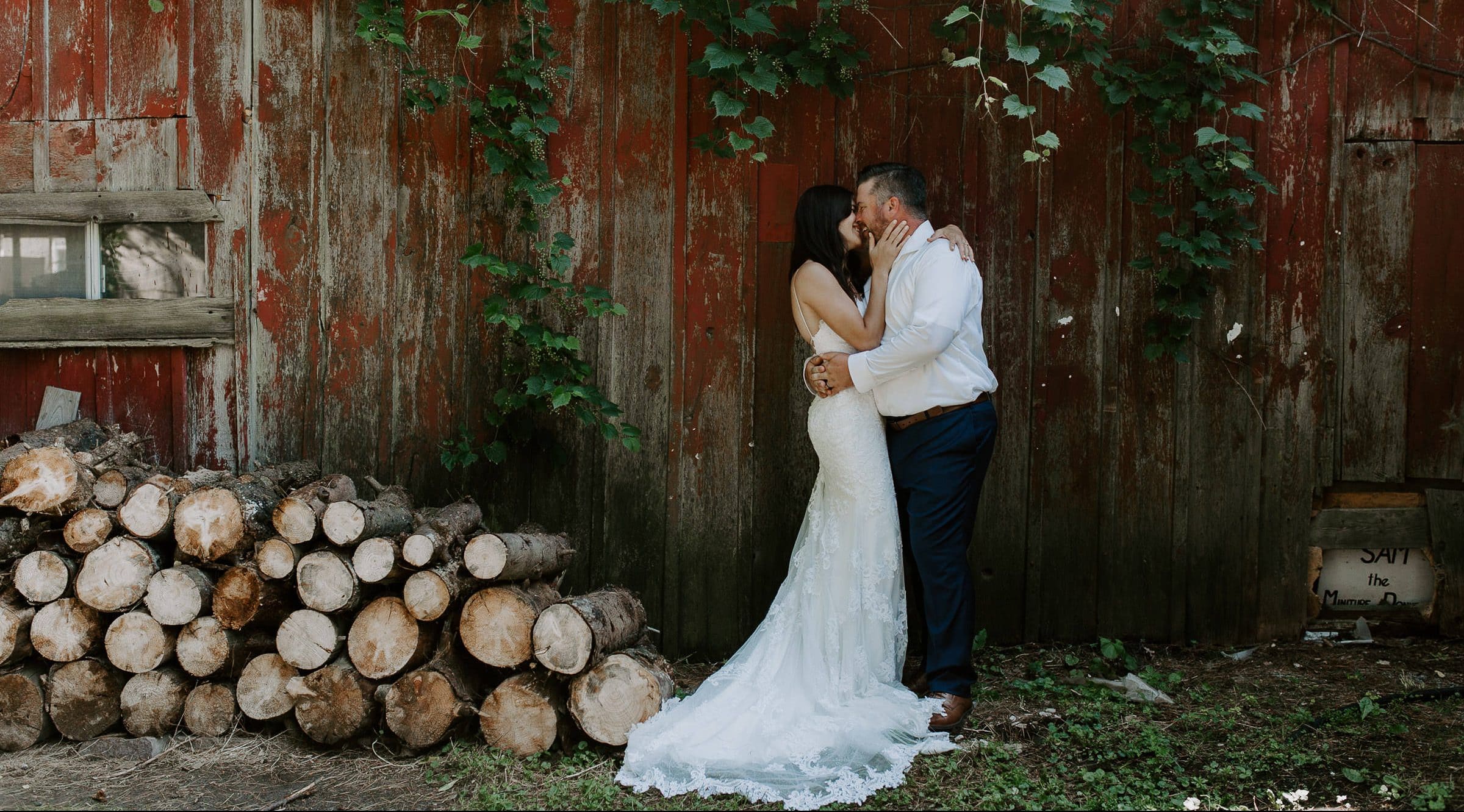 A couple enjoying a kiss in front of a barn at their backyard small wedding in Fonthill Ontario