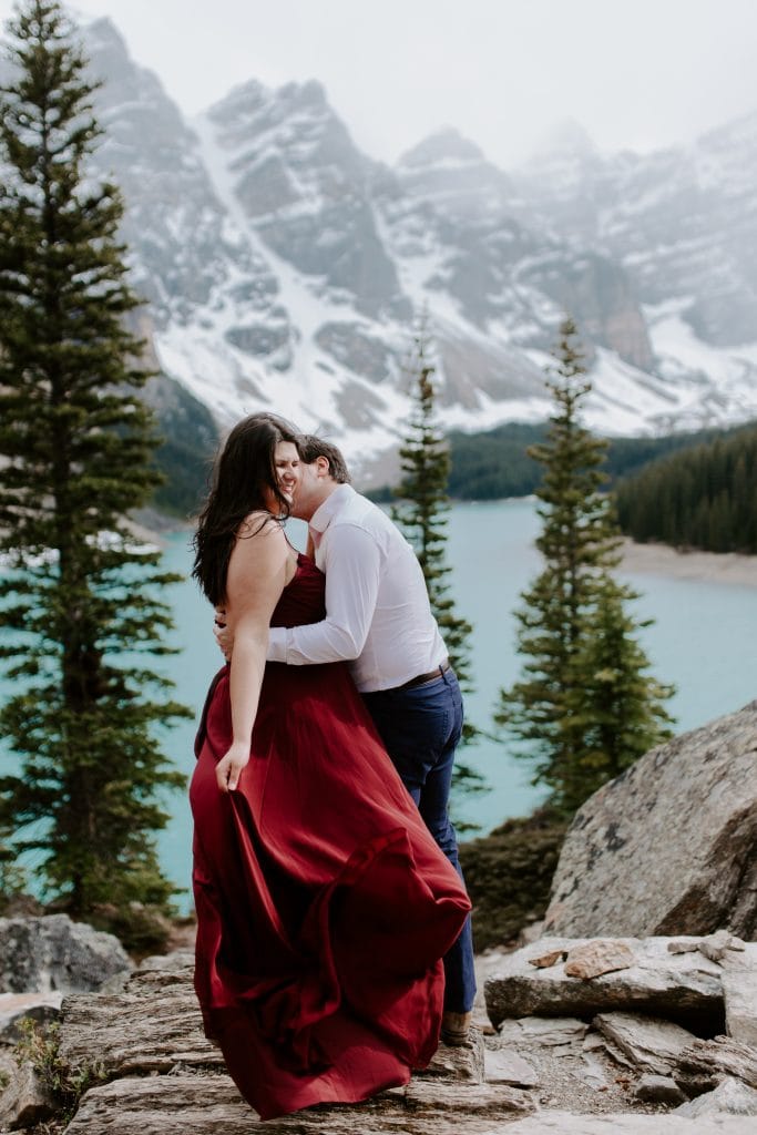 A couple eloping in Banff, on top of the rocks at Moraine Lake. Banff elopement photographer