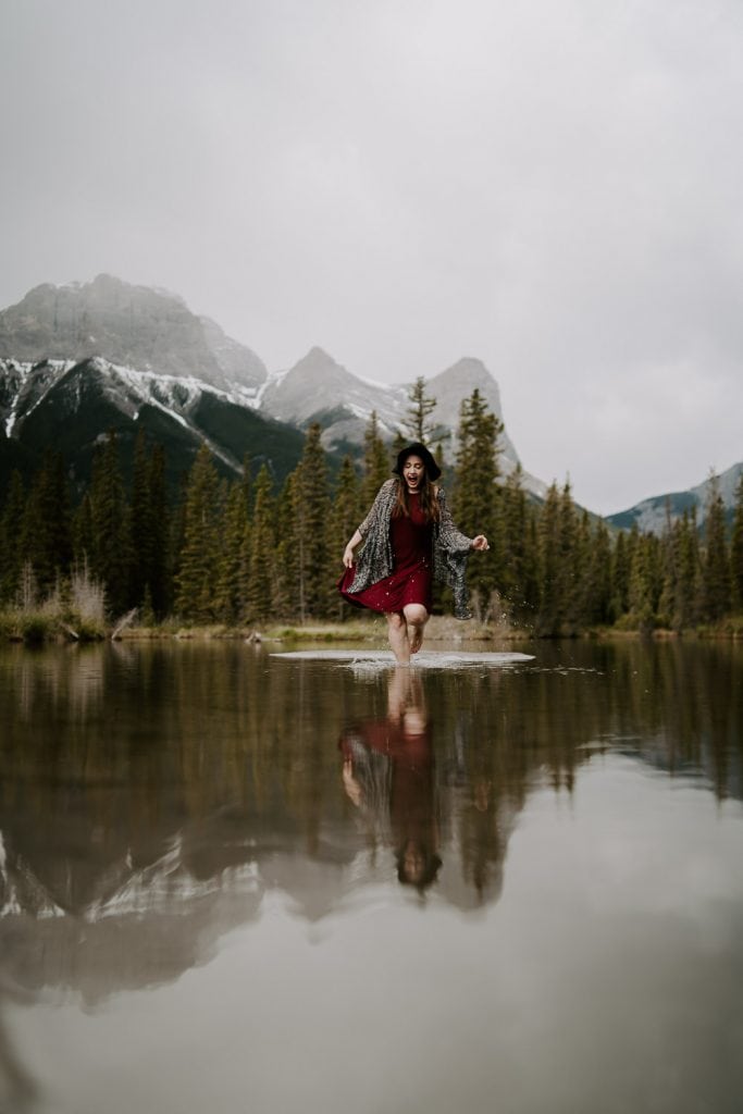 Wedding, Couple Session Elopement Photographer walking through a pond with mountains in the background