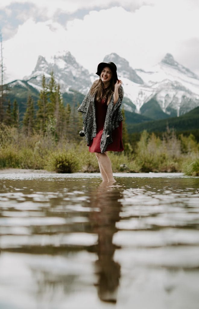 Destination Elopement Wedding Photographer in standing in a lake in front of mountains.