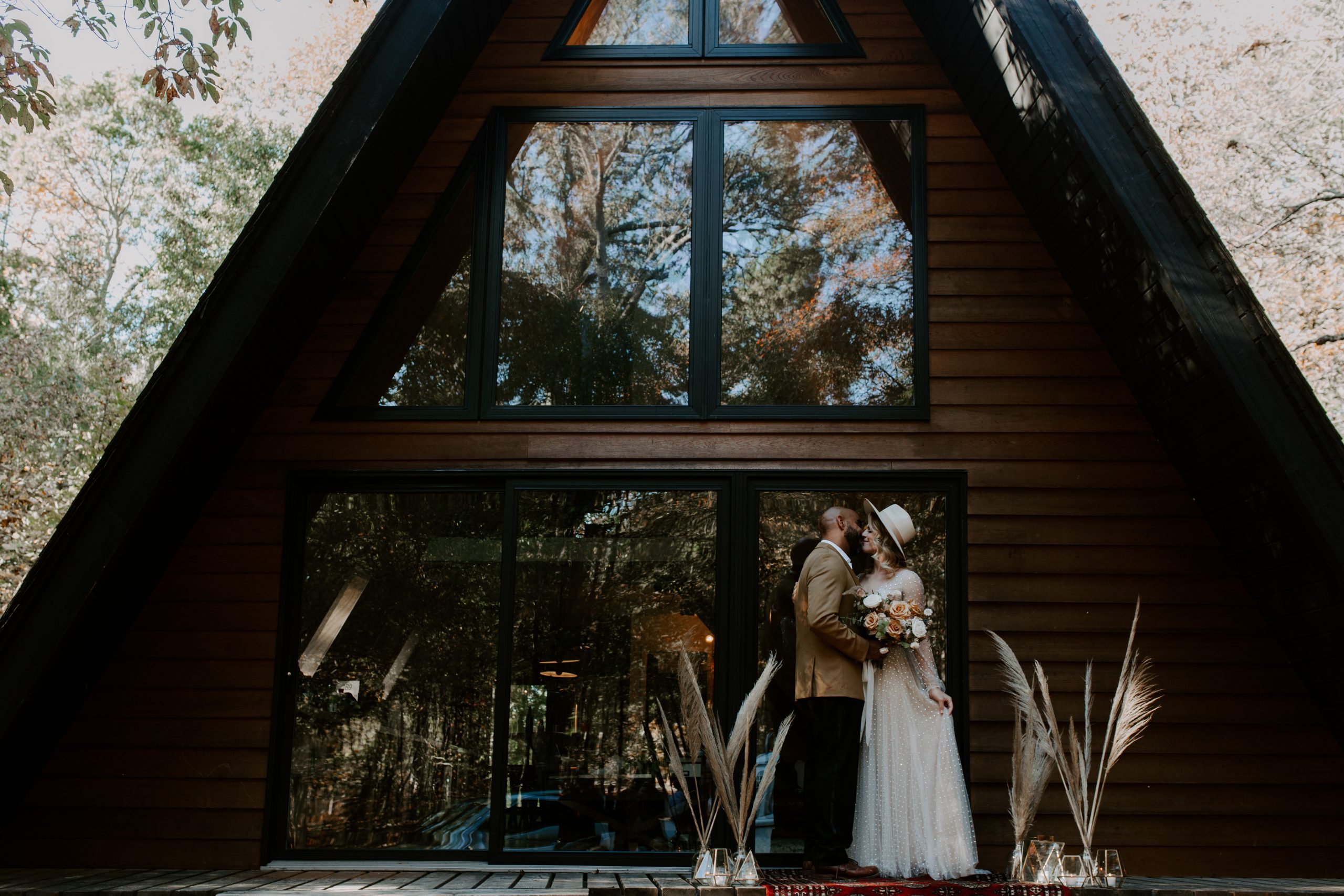 Couple standing on the front porch of their cabin getting married. Muskoka elopement photographer